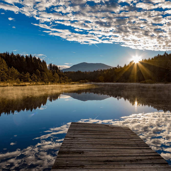 Bergsee in Kärnten mit Steg in das Wasser.