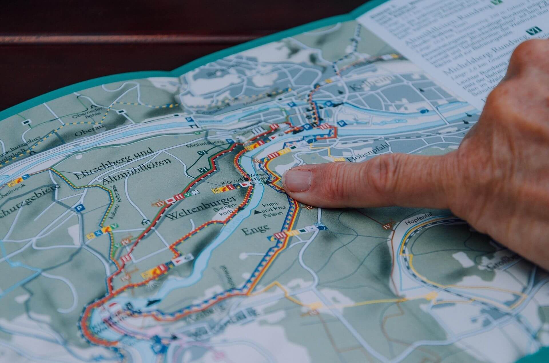 Mit dem Finger auf der Landkarte das Ziel der Reise finden.